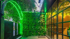 Um espaço interno moderno com parede verde, portas de vidro e área de estar.