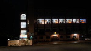 A multi-story building with illuminated windows and a visible entrance. - Itsy Hotels Mansi (Nashik)