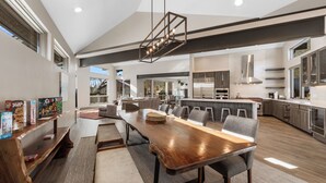 A spacious kitchen with a long wooden table, modern appliances, and a large island. - 200cdk5 (Keystone)