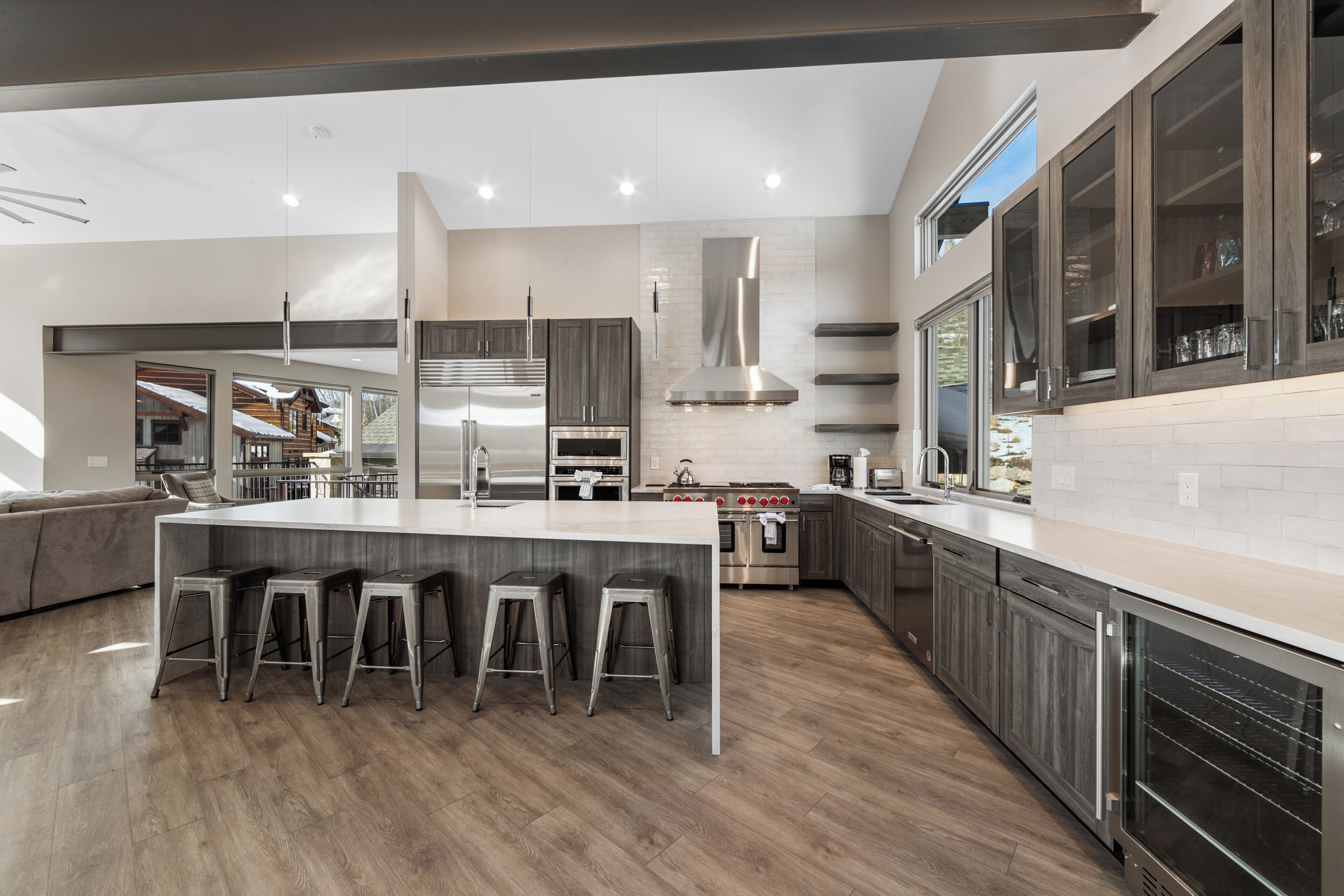 A modern kitchen with a large island, stainless steel appliances, and a bar stool seating area.