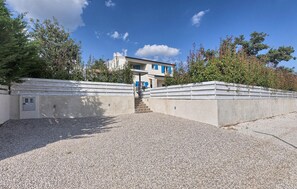A building with a concrete facade, a staircase leading to a door, and a gravel ground. - Amazing home in Zminj with sauna (Zminj)
