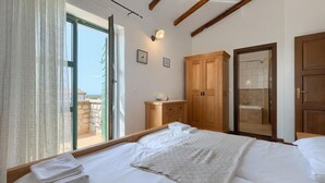 Una camera da letto con un letto grande, un armadio in legno e un bagno con doccia.