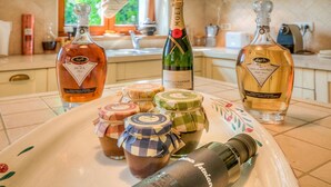 Una encimera de cocina con varias botellas de licor, incluyendo una botella de champán Moët & Chandon, y varios pequeños frascos de mermelada o conservas.