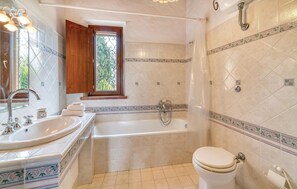 A bathroom with a bathtub, toilet, and sink. - 2 bedroom nice home in Follonica (Follonica)