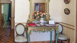 A room with a marble table, two chairs, a vase with flowers, and a mirror with a decorative frame. - Nice home in Pierre-Châtel with WiFi (Pierre-Châtel)