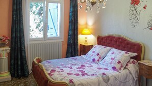 A bedroom with a bed, a window, a lamp, and a floral wall decoration. - Nice home in Pierre-Châtel with WiFi (Pierre-Châtel)