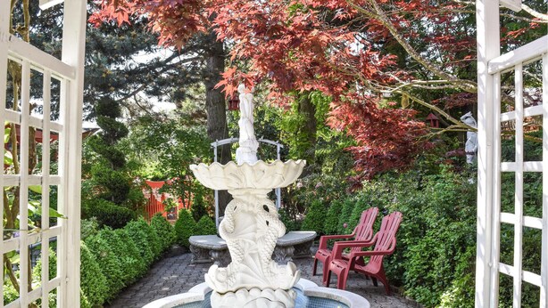 A garden with a central fountain, red chairs, and a white fence. - Nice home in Pierre-Châtel with WiFi (Pierre-Châtel)