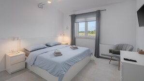 A modern bedroom with a large bed, bedside tables, a desk, and a view of the outdoors. - Awesome home in Buzinija with private swimming pool, can be inside or outside (Buzinija)