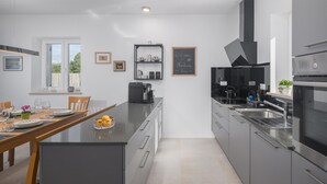 A modern kitchen with grey cabinetry, a central island, and a chalkboard sign. - Awesome home in Buzinija with private swimming pool, can be inside or outside (Buzinija)