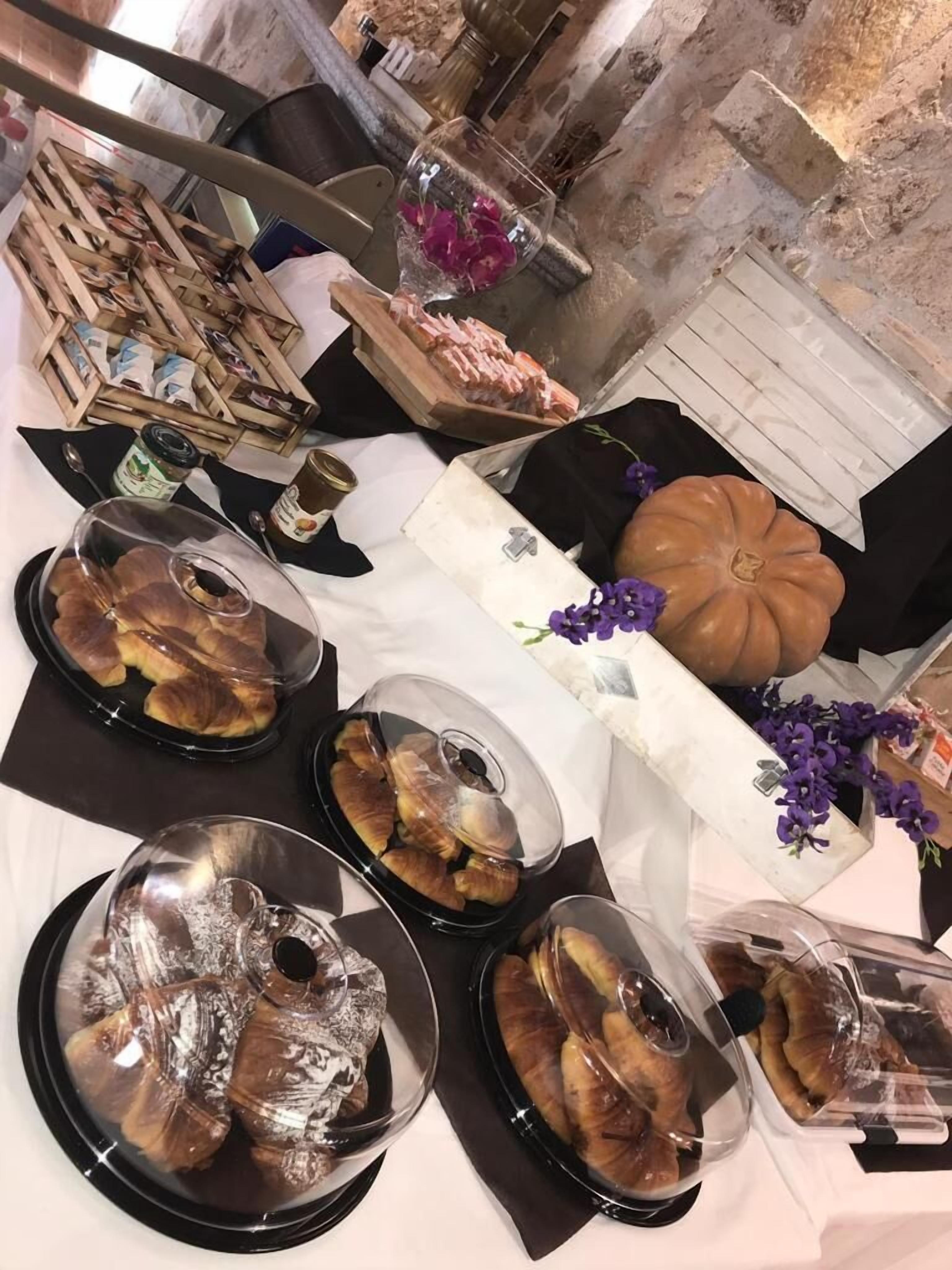 Una mesa de buffet con diferentes alimentos, incluyendo pasteles y un centro de mesa con una calabaza.