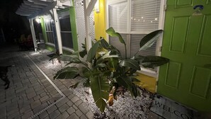 Un bâtiment avec une porte verte, un mur jaune et un auvent blanc.