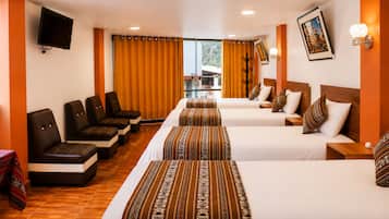 A hotel room with two beds, a seating area with chairs, a television, and a window with curtains.