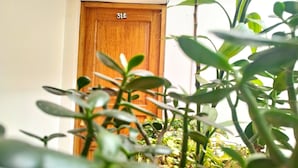 A wooden door with the number 312, surrounded by greenery. - Amakonkay Machupicchu (Machu Picchu)