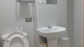 Een moderne badkamer met toilet, wastafel en douche.