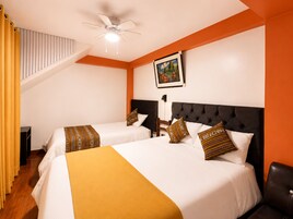 Habitación de hotel con dos camas, un ventilador de techo, un cuadro en la pared y una escalera.