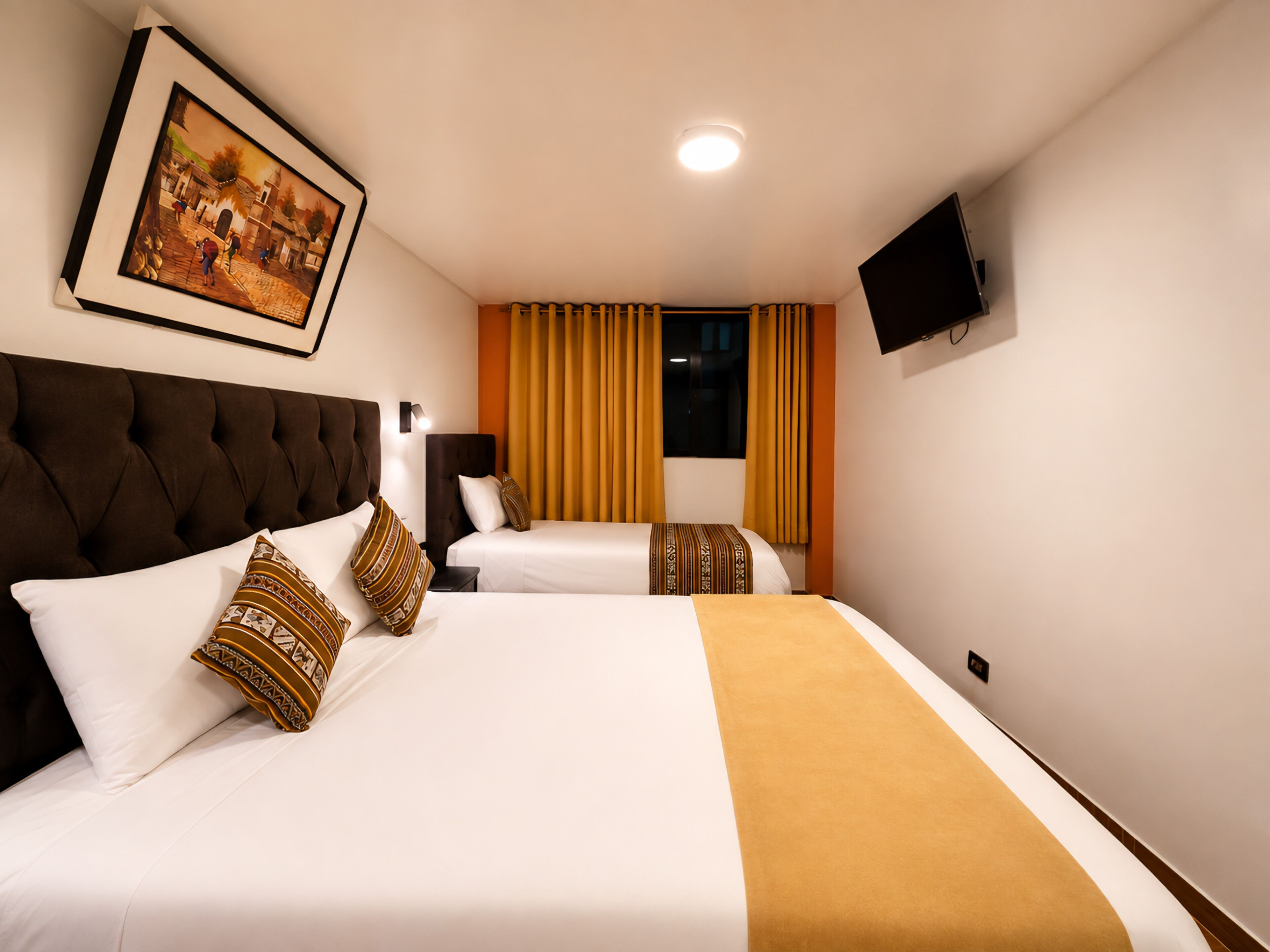A hotel room with two beds, a large painting, a flat-screen TV, and a window with curtains.