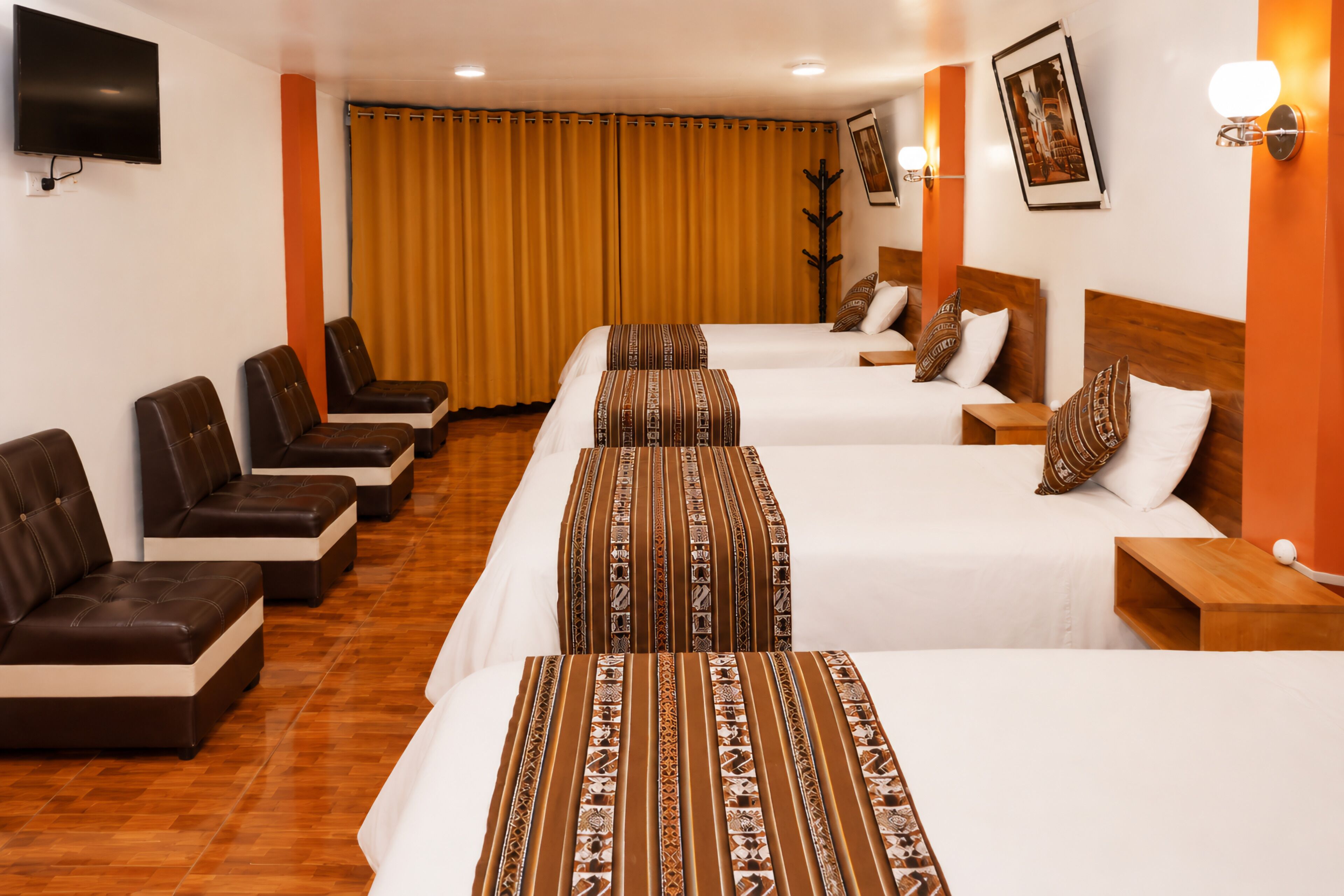 A hotel room with two beds, a TV, a coat rack, and a large window with curtains.