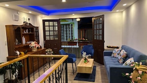 Una sala moderna con un sofá azul, una mesa de centro de madera y un aparador decorativo.