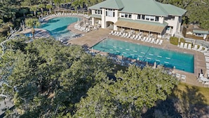 A resort with a large pool, lounge areas, and a building with a green roof. - Beautiful Salt Marsh Cottage in Moss Creek, where serenity awaits. (Hilton Head Island)