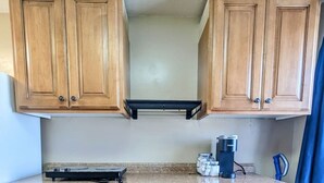 A kitchen with wooden cabinets, a countertop, a coffee maker, and a toaster. - Spacious 3BR Basement Apt | Airport, Work, Ski (North Salt Lake)