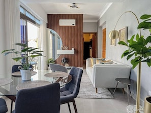 A modern living room with a sofa, chairs, a coffee table, and a dining area with a table and chairs. - Goistay Elegant Refugio Caribeño 1br Gym Pool Naco APT 9F (Santo Domingo)