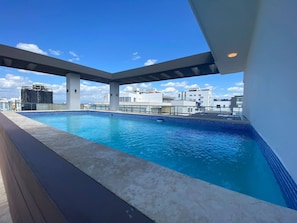 A rooftop swimming pool with a view of surrounding buildings. - Goistay Elegant Refugio Caribeño 1br Gym Pool Naco APT 9F (Santo Domingo)