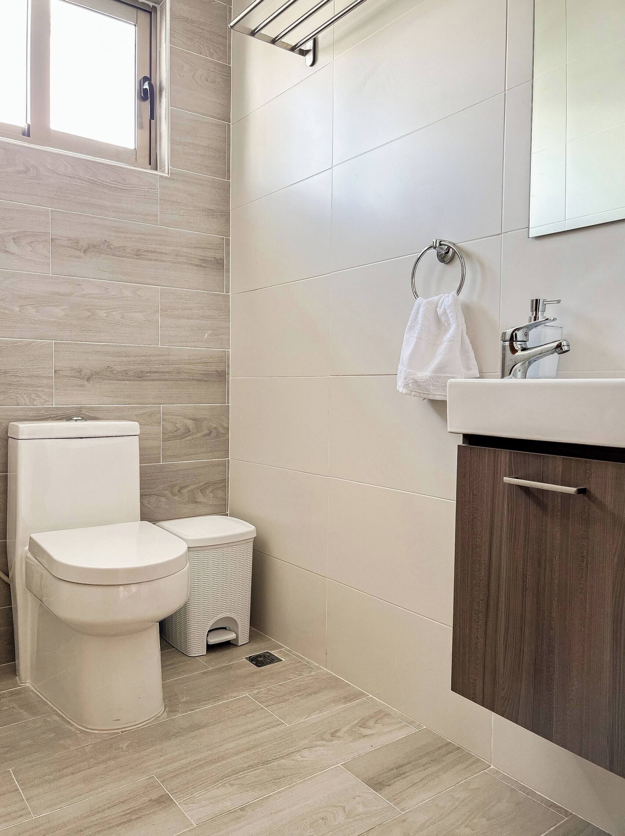 A modern bathroom with a toilet, bidet, and sink.