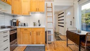 Una cocina moderna con armarios de madera, una estufa de acero inoxidable y vistas a un balcón.