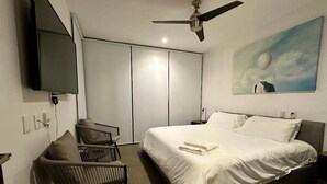 A bedroom with a bed, a desk, a chair, a ceiling fan, a TV, and a painting on the wall. - Depa Asoluta, Cerquita de TODO en el Norte de Mérida. CoWorking (Mérida)