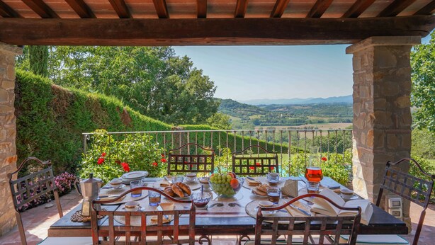 A covered outdoor dining area with a table set for a meal, overlooking a scenic landscape. - La Vista by Interhome (Vicchio)