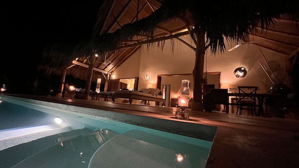 A poolside area with lounge chairs and a thatched-roof structure. - Las Terrenas - Caribbean Villa for 6 People - Exceptional Location (Las Terrenas)