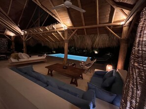 An indoor pool area with a wooden ceiling, lounge chairs, and a sofa. - Las Terrenas - Caribbean Villa for 6 People - Exceptional Location (Las Terrenas)