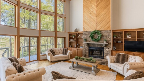 A spacious living room with large windows, a fireplace, and a television. - Cabin by the Bluff (Altamont)