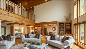 A spacious living room with high ceilings, a dining area, and a kitchen. - Cabin by the Bluff (Altamont)