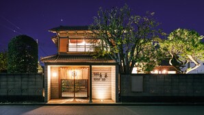 A two-story building with a traditional architectural style, featuring a wooden facade and a large tree in front. - Machi-jyu  (Chichibu)