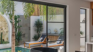Un espace de vie extérieur moderne comprenant une piscine, des chaises longues et une table à manger.