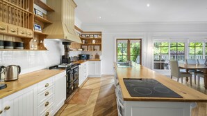 Una cucina moderna con mobili in legno, un piano cottura integrato e una grande isola.