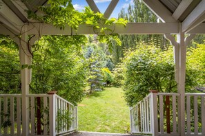 Relax in a serene garden setting beneath a charming pergola with lush greenery all around.