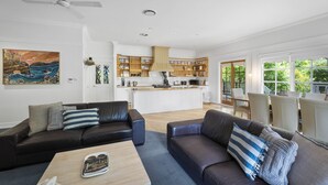Un soggiorno moderno con due divani, un tavolino da caffè e un'area cucina sullo sfondo.