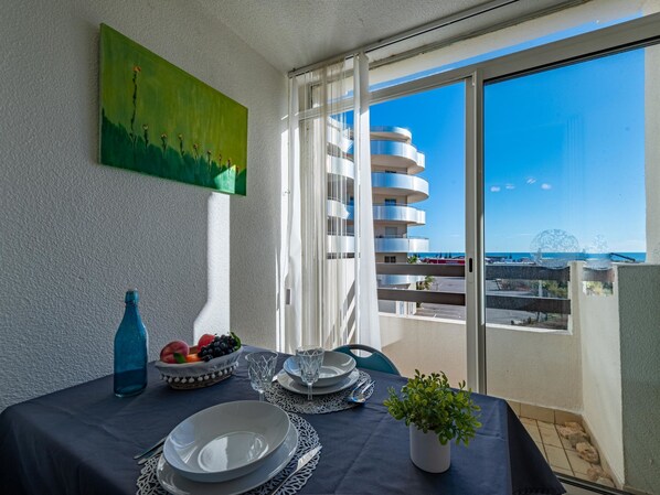 A balcony with a view of a modern building and the sea.