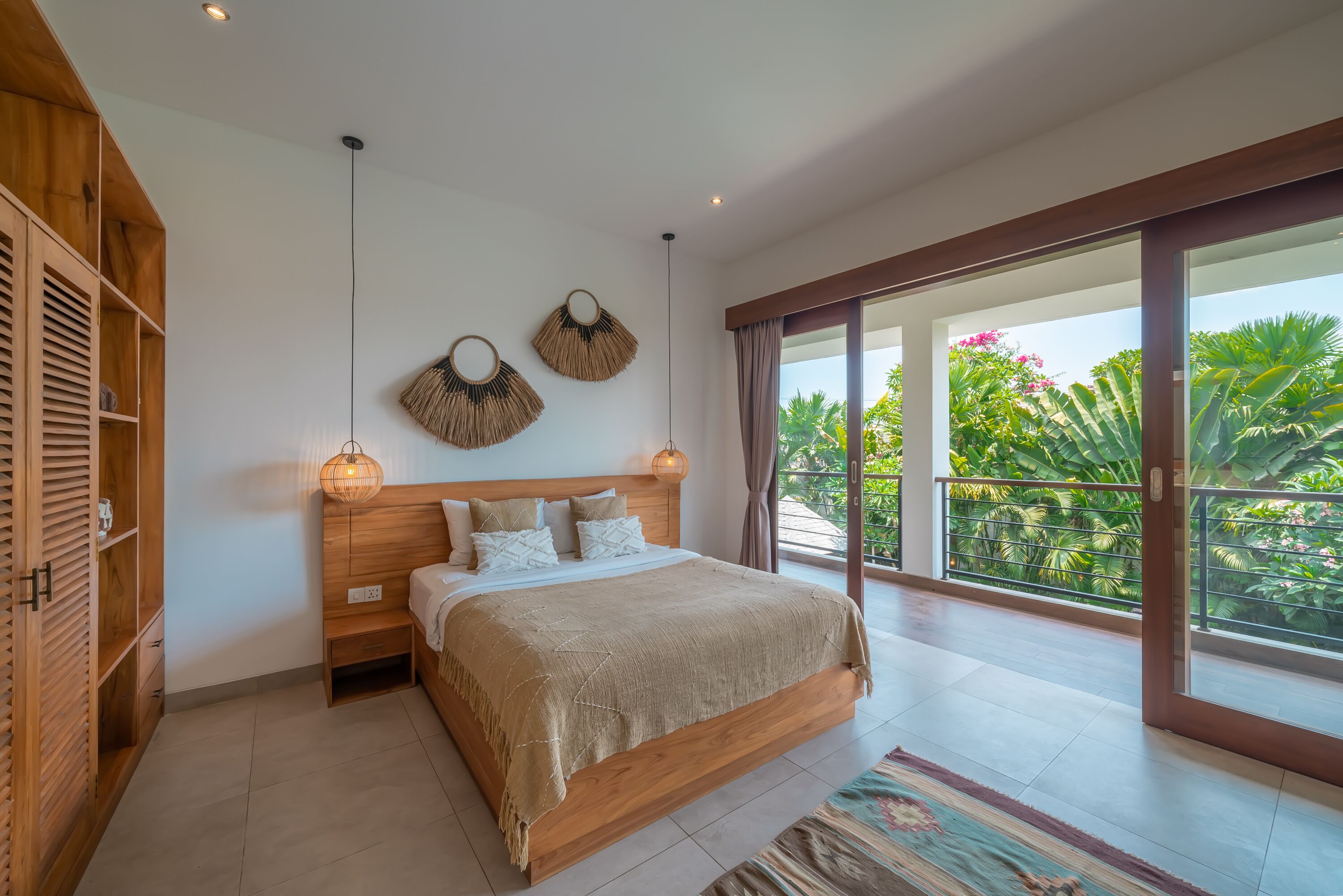 A modern bedroom with a wooden bed, a large window, and a view of greenery.