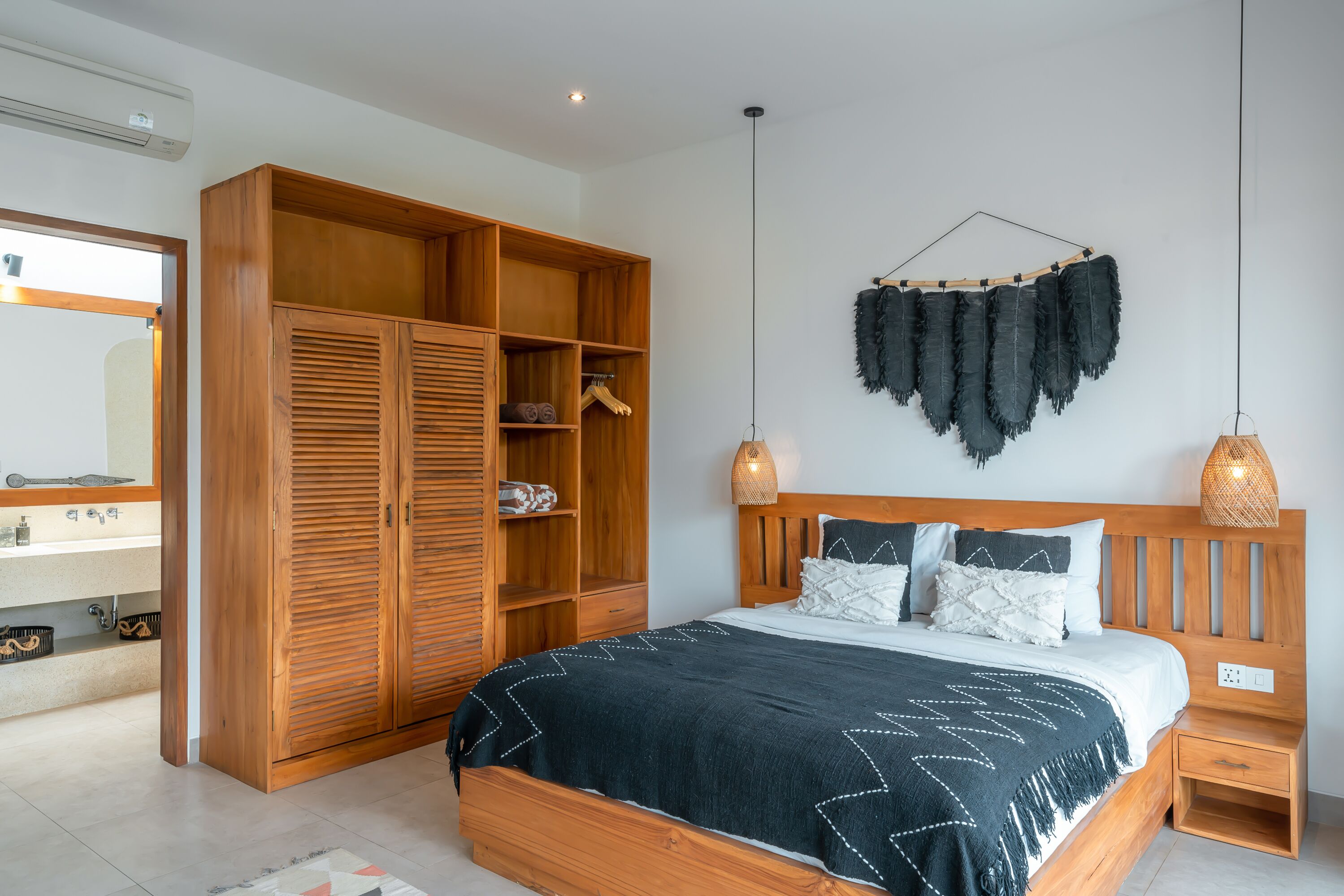 Een slaapkamer met een houten bed, een kledingkast en een hanglamp.