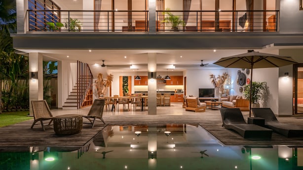 A modern two-story house with a spacious outdoor area, including a pool and lounge seating. - Villa Lisy  (Canggu)