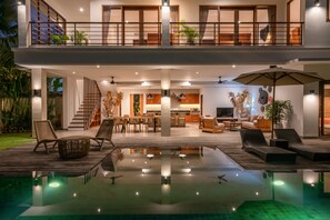 A modern two-story house with a spacious outdoor area, including a pool and lounge seating. - Villa Lisy (Canggu)