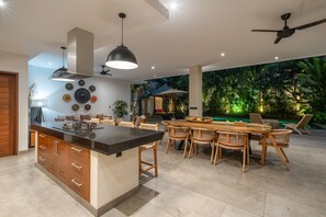 Enjoy meals in the kitchen with a central island and dining area, adjacent to a serene indoor garden.
