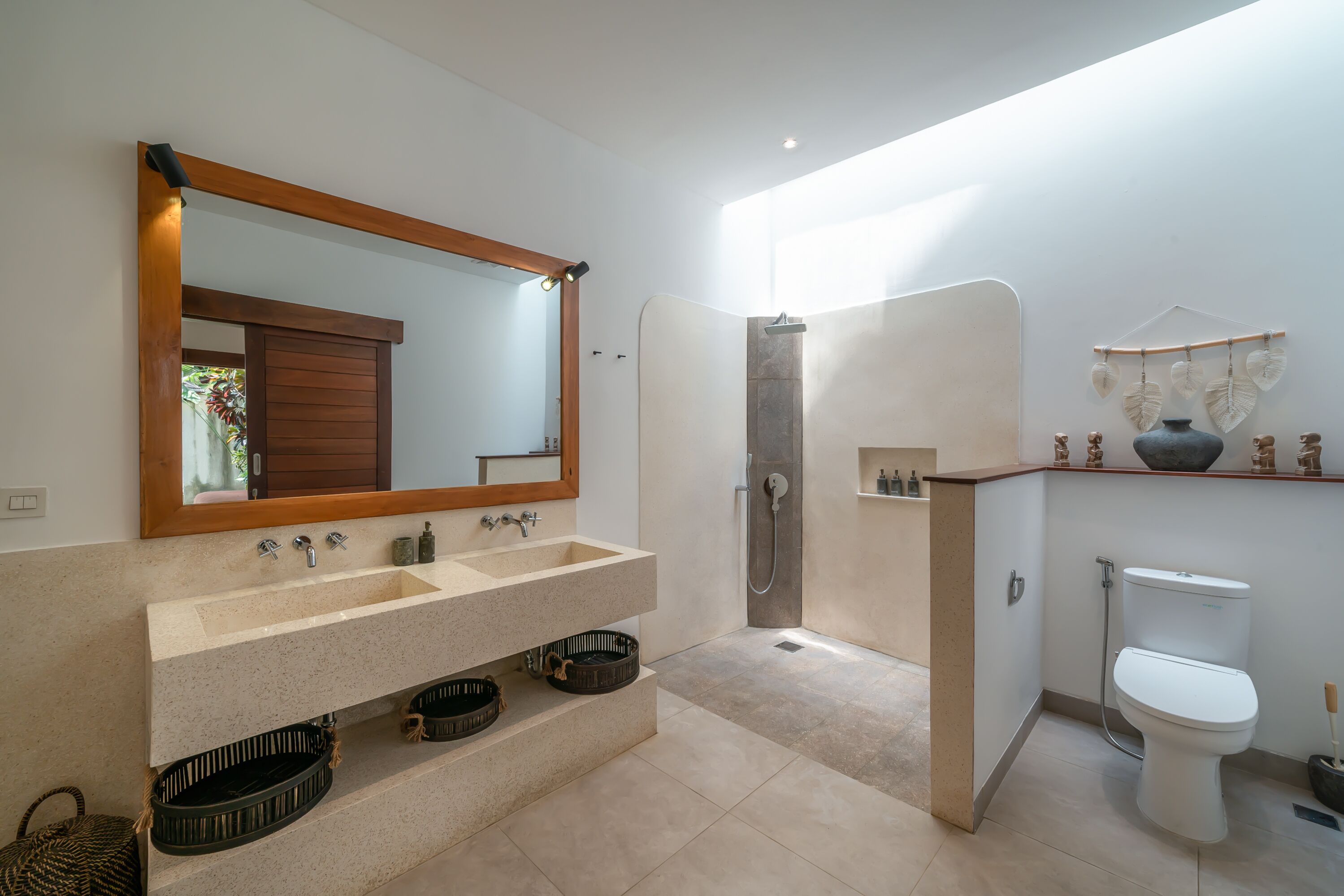 Ein modernes Badezimmer mit großem Spiegel, zwei Waschbecken, einer Dusche und einer Toilette.