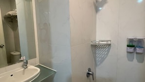A bathroom with a glass sink, a shower with a handheld showerhead, and a towel rack. - Praya Room (South Tangerang)