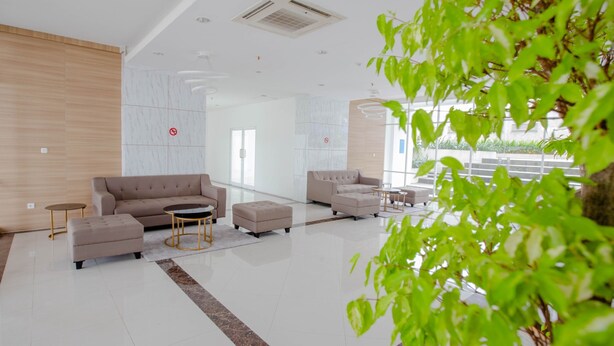 A modern lobby with a sofa set, ottomans, and a coffee table. - Praya Room (South Tangerang)