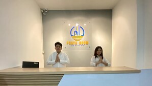 A reception desk with a logo for 'PRAYA ROOM' and a sign indicating a prayer room. - Praya Room (South Tangerang)
