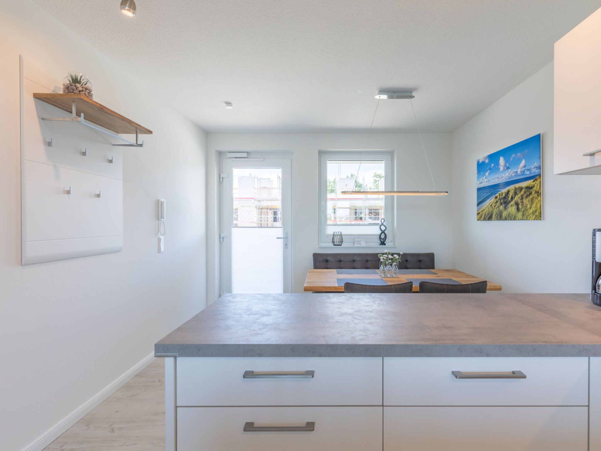 A modern kitchen with a large island, built-in cabinets, and a window with a view.